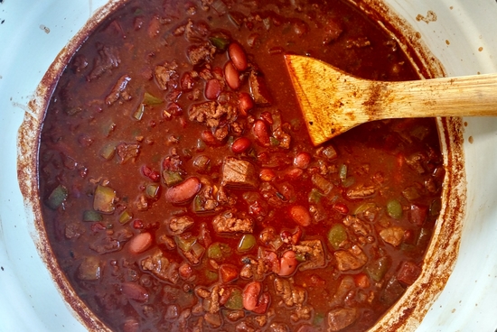 Perfect Steak Chili in a dutch oven with a serving spoon