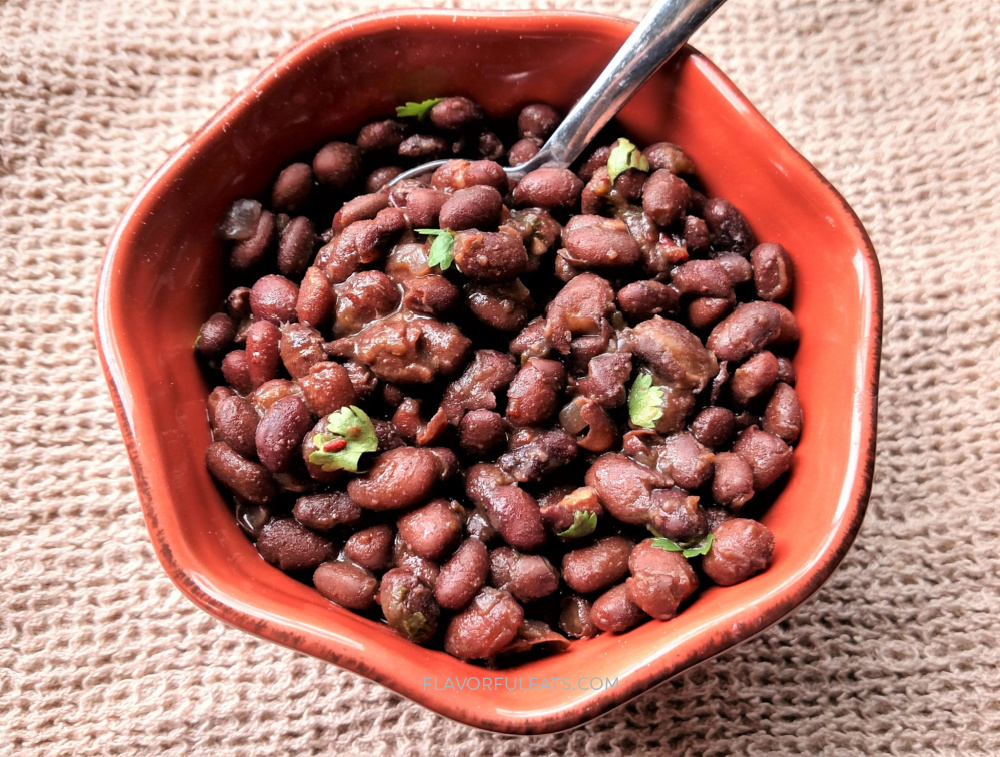A clay bowl filled with Smoky Slow Cooker Mexican Black Beans