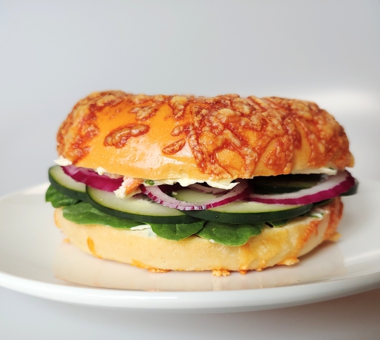 A veggie bagel sandwich with fresh vegetables and Garlic & Scallion Cream Cheese Spread