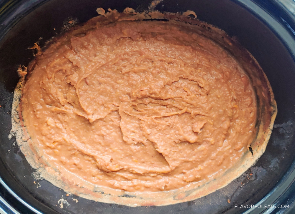 slow cooker with cooked refried beans blended smooth