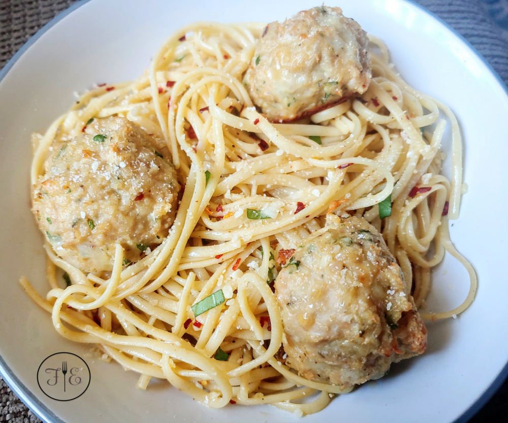 Baked Italian Chicken Meatballs on a plate with spaghetti
